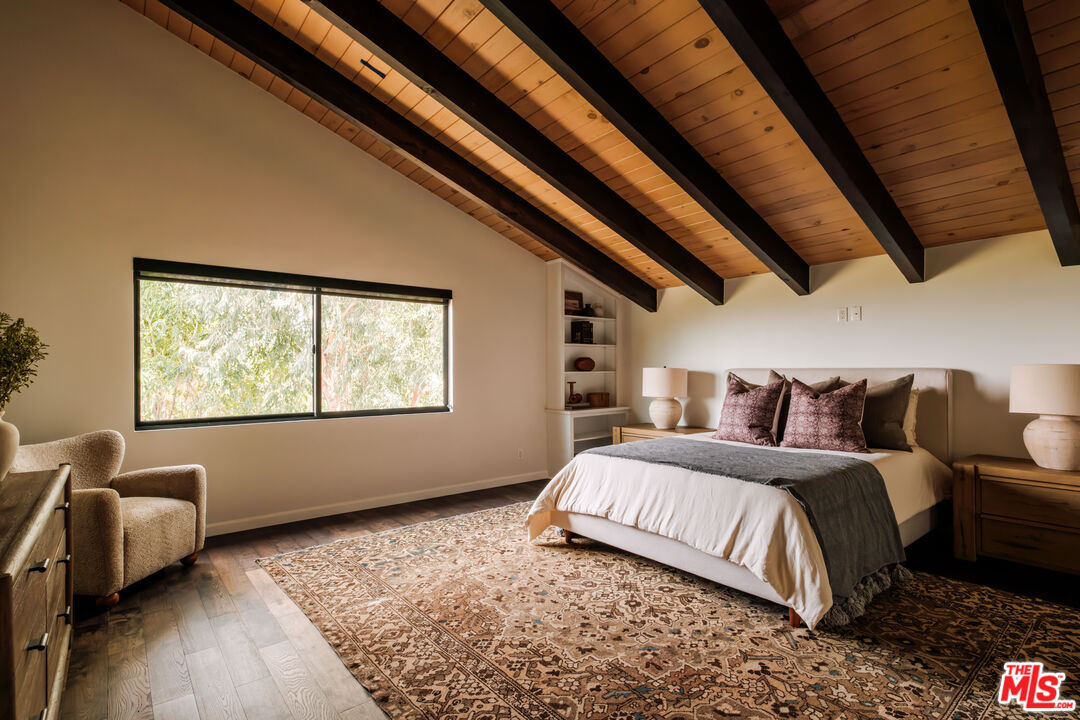 Bedroom with a vintage patterned rug and wood ceiling beams