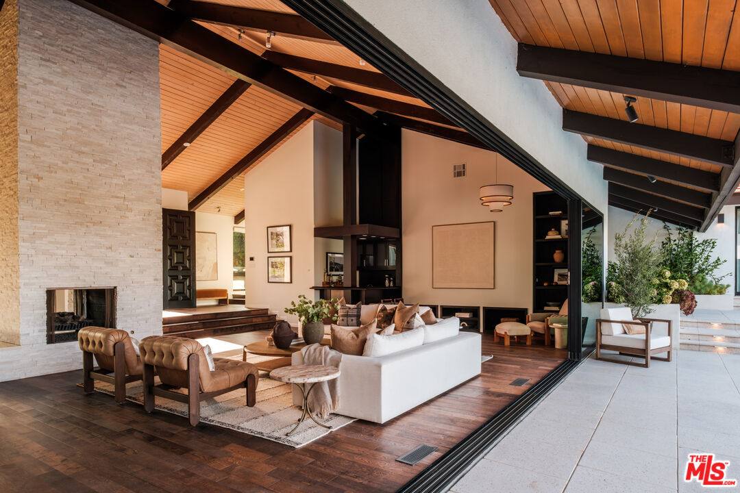 Living room with disappearing glass walls open to the pool terrace and mountain view