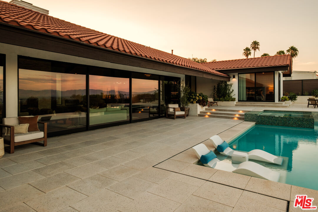 Sunset reflected in the glass doors beside the pool terrace