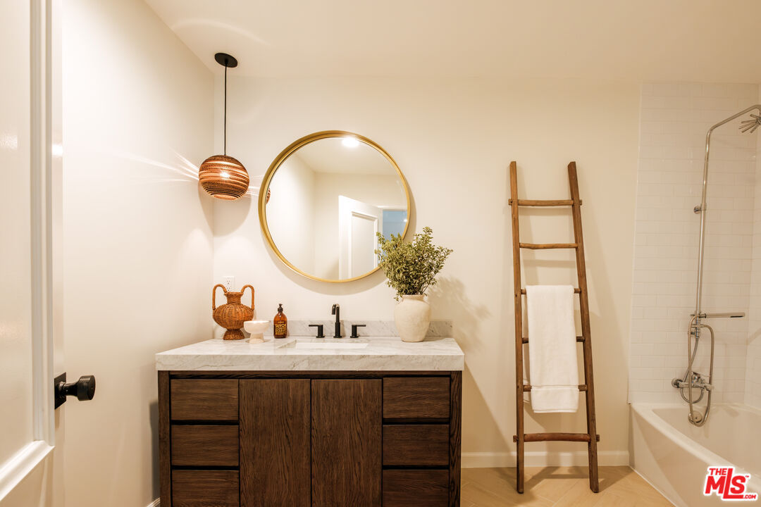 Powder bath with a round brass mirror and wooden towel ladder