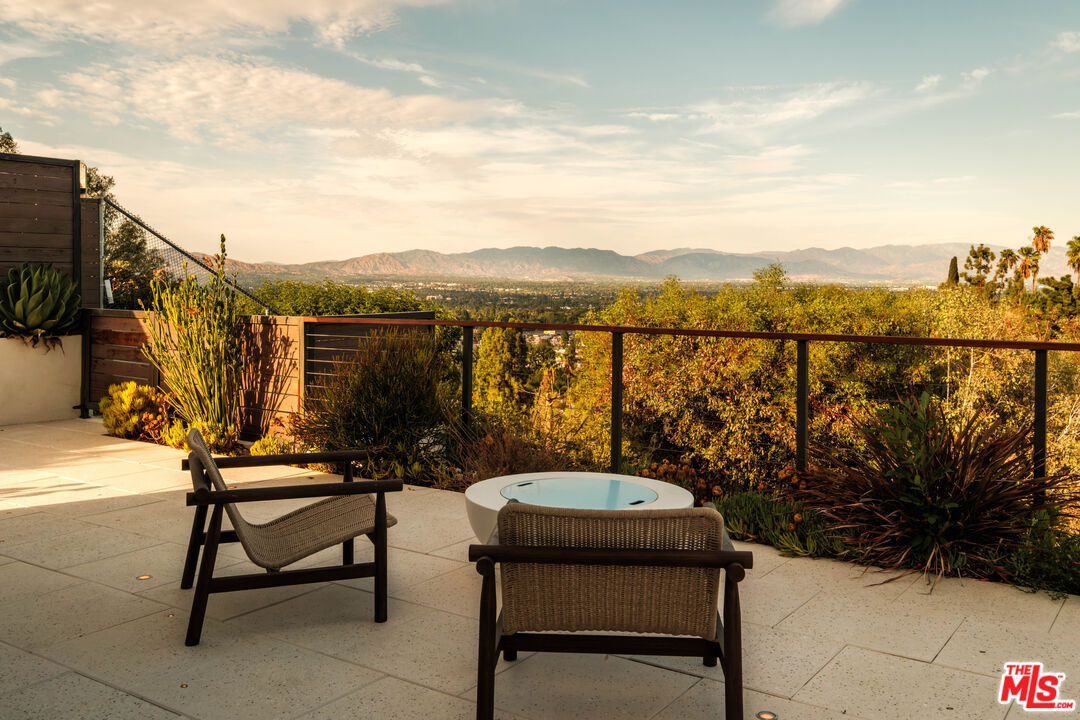 Corner terrace seating with a fire table facing the mountain view